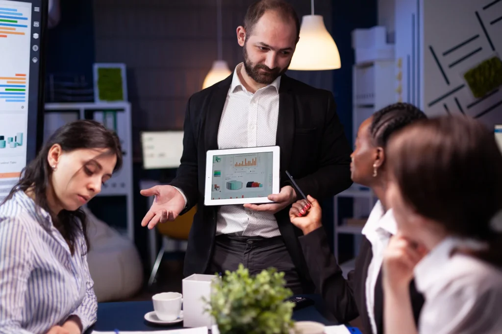 eam presentation showcasing Zohos integrated business tools on a tablet during a meeting